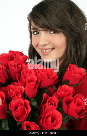 Mädchen versteckt sich hinter einem Strauß roter Rosen Stockfoto