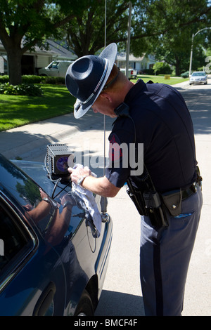 Nebraska State Trooper Reinigung automatisiert License Plate Reader, der auf seinem Streifenwagen montiert ist. Stockfoto