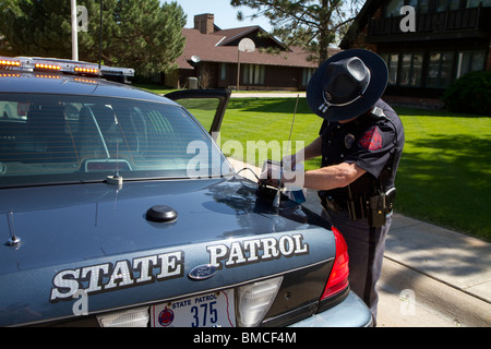 Nebraska State Trooper Reinigung automatisiert License Plate Reader, der auf seinem Streifenwagen montiert ist. Stockfoto