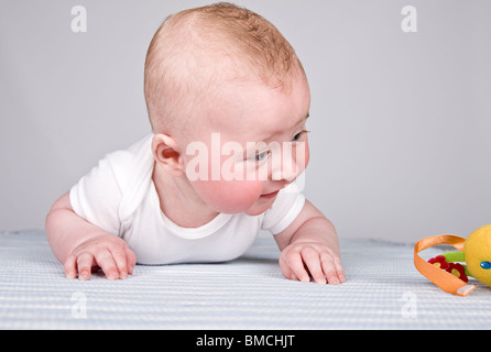 Vier Monate alten Baby Boy Blick auf sein Spielzeug Stockfoto