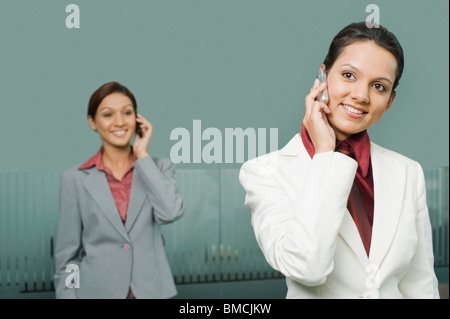 Zwei Unternehmerinnen im Gespräch auf dem Handy Stockfoto