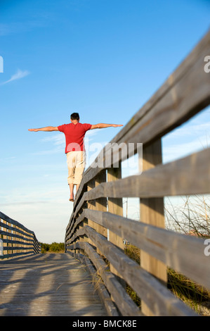 Mann, balancieren auf Holzgeländer, Honeymoon Island, Florida, USA Stockfoto