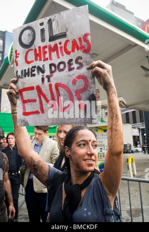 Demonstranten verschütten flüssiges Öl vertritt über sich selbst vor einer BP-Tankstelle in New York Stockfoto