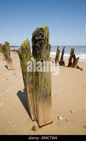 Hölzernen Pfosten und verdreht rostigen Metall entlang Happisburgh Küste, Norfolk. Stockfoto