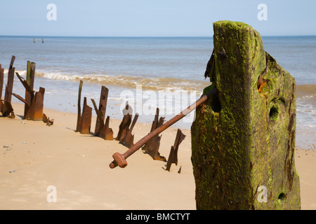 Hölzernen Pfosten und verdreht rostigen Metall entlang Happisburgh Küste, Norfolk. Stockfoto