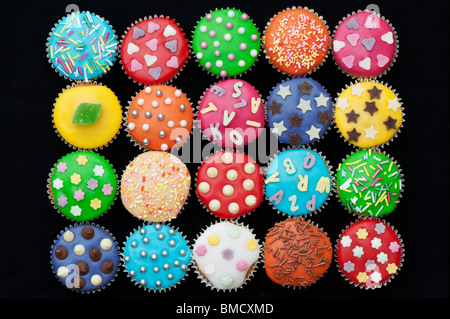 Bunte Mini Cupcakes auf schwarzem Hintergrund Stockfoto