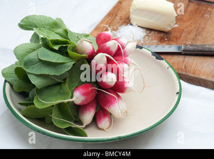 Frische Radieschen In eine Emaille-Schüssel, mit Butter, Salz und ein Messer im Hintergrund