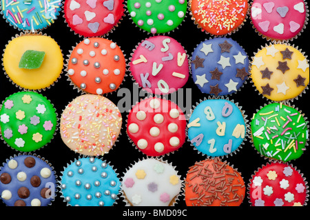 Bunte Mini Cupcakes auf schwarzem Hintergrund Stockfoto