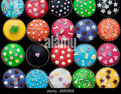 Bunte Mini Cupcakes auf schwarzem Hintergrund Stockfoto