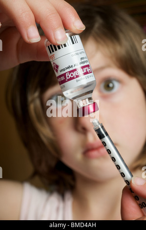 6 - Jahre altes Mädchen, die Ausarbeitung einer Insulininjektion Stockfoto