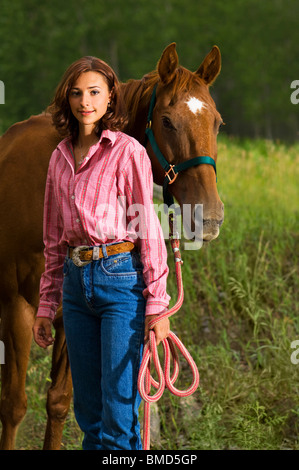 Mädchen steht mit ihrem Pferd an ihrer Seite. Stockfoto