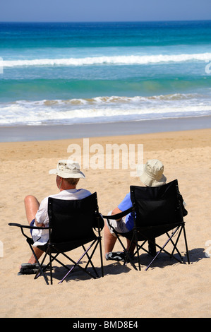 ein Mann und eine Frau sitzt am Strand in Cornwall, Großbritannien Stockfoto
