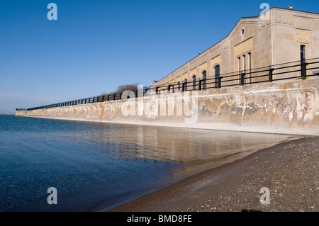 Deich mit Geländer auf der Oberseite und Art-Deco-Gebäude im Hintergrund Stockfoto