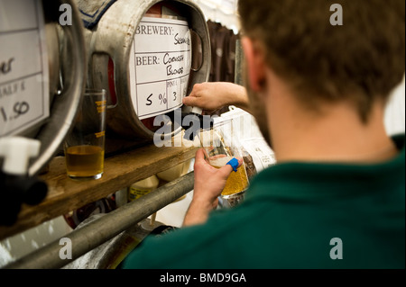 Ein Barangestellter goss beim Hoop Beer Festival in Essex ein Pint echtes Ale. Stockfoto