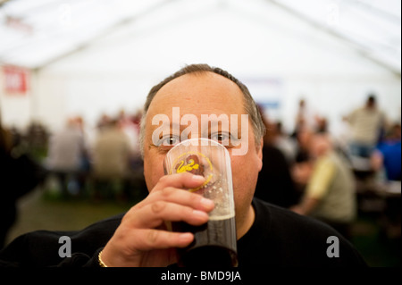 Ein Kunde trinkt ein Pint Ale am Hoop Beer Festival in Essex. Stockfoto