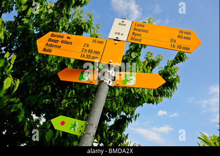 Schweizer Wanderweg Schild am Dorf Vinzel im Kanton Waadt. Das Zeichen für eine Nordic-walking-Strecke (grün) darunter. Stockfoto