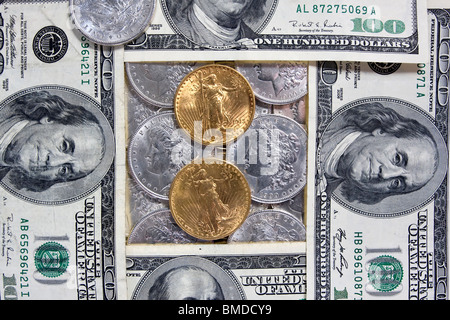 Gold- und Silbermünzen sind mit hundert-Dollar-Scheine verflochten. St. Gaudens gold Double Eagles, Morgan Silberdollars und Fran Stockfoto