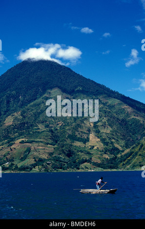 Maya Mann poling ein Boot am Lake Atitlan, Guatemala Stockfoto