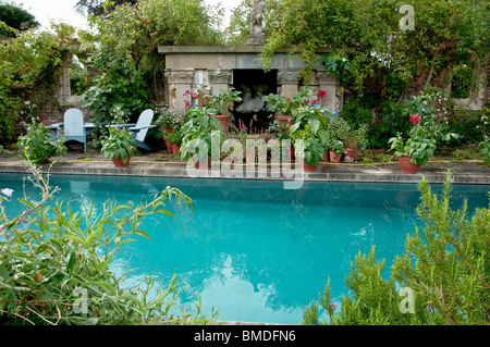 Schwimmbad mit umliegenden Töpfe und Pflanzen am jüngere Court Gardens, Cotswolds, UK Stockfoto