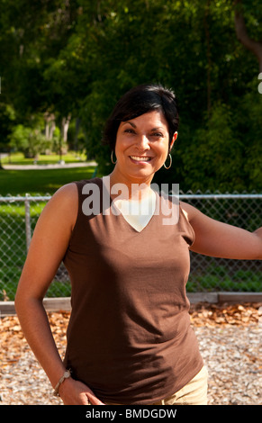 Schöne Hispanicwoman in ihren 30ern Porträt draußen im Park Stockfoto