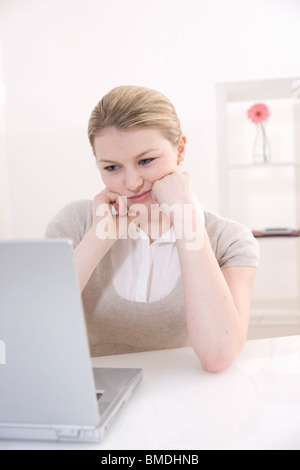 Gelangweilte Geschäftsfrau mit Laptop Stockfoto