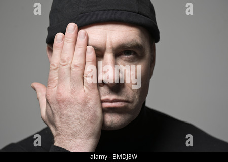 Manndeckung einer Seite seines Gesichts Stockfoto