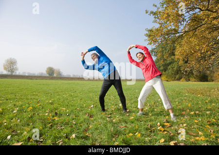 Paar Stretching im Feld Stockfoto