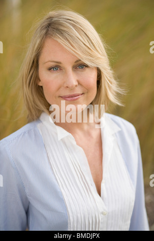 Porträt von blonde Frau sitzt in hohe Gräser, Model-release Stockfoto