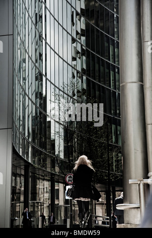 Geschäftsfrau, die hinunter Lime Street im Finanzzentrum von London Stockfoto