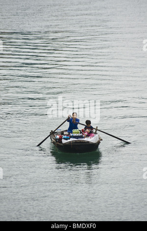 Mutter und Kind, Verkauf von Essen und Trinken von Rudern Boot in der Halong Bucht, Vietnam Stockfoto