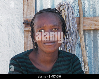 Eine Mädchen sitzt draußen eine provisorische Zuflucht in einer Verschiebung Lager für diese obdachlos durch eine Reihe von Hurrikanen, Gonaives, Haiti Stockfoto