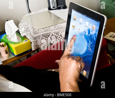 Asiatische Frau, die mit dem Apple iPad, TouchscreenTablet Computer, Book-Reader, Digital Ebook, Modern, Logo, Marke, Luxus Stockfoto