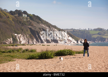 Großbritannien, England, Devon, Strete Tor Frau zu Fuß klein Hund auf Slapton Sands beach Stockfoto