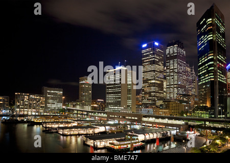 Sydney CBD in der Nacht vom kreisförmigen Tasten mit Fähren und Terminal im Vordergrund Stockfoto