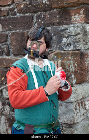 Mann (MR) eingeschlossen in einem Branks oder Schimpfbraum, einem mittelalterlichen Foltergerät. Eine grausame Bestrafung, die benutzt wird, um diejenigen zu bestrafen, die aus der Reihe waren. Schottland Stockfoto