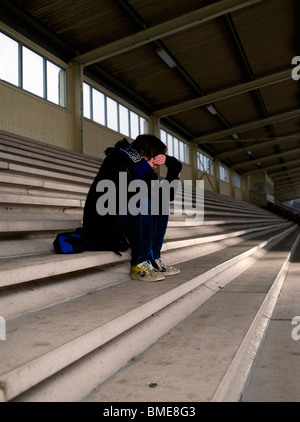 Junge sitzt auf der Treppe in depression Stockfoto