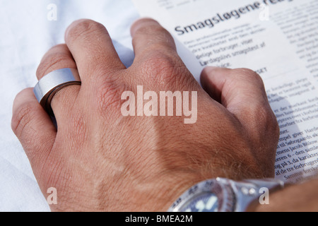 Menschliche Hand auf Zeitungspapier mit ring Stockfoto