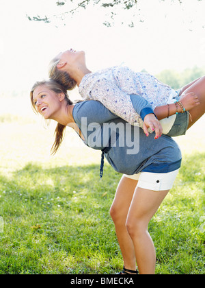 Junge Frau Freund auf dem Rücken heben Stockfoto