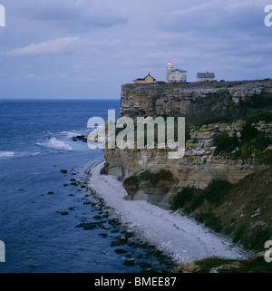 Leuchtturm auf Felsen in der Abenddämmerung Stockfoto