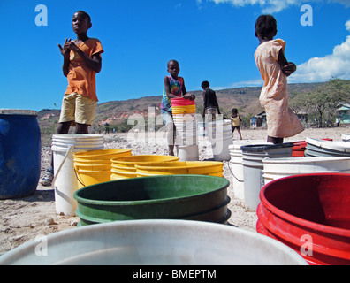 Kinder warten auf Wasserverteilung durch die Vereinten Nationen in der staubigen Halbwüste außerhalb Gonaives, Haiti Stockfoto