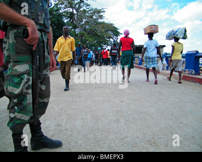 Haitianer tragen Produkte über die Dominikanische Republik - Haiti-Grenze für den Wochenmarkt, wie UN-Friedenstruppen Wache stehen Stockfoto