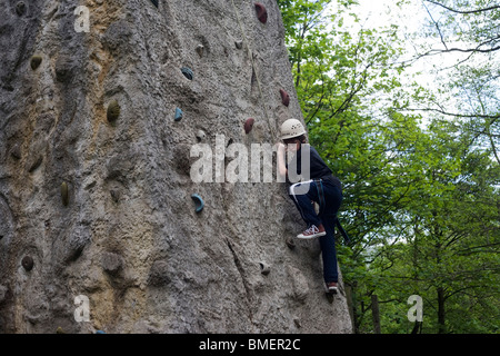 12 jähriger Junge der Turm in Wäldern am YHA Edale klettern. Stockfoto