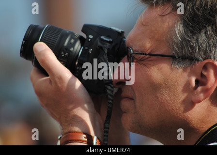 Ein Mann mit Brille nimmt ein Foto mit einer digitalen slr-Kamera, Venedig, Italien Stockfoto