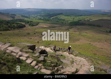 Wanderer in der Nähe von oben Stanage Edge Gritstone Klippen, Peak District National Park, Derbyshire. Stockfoto