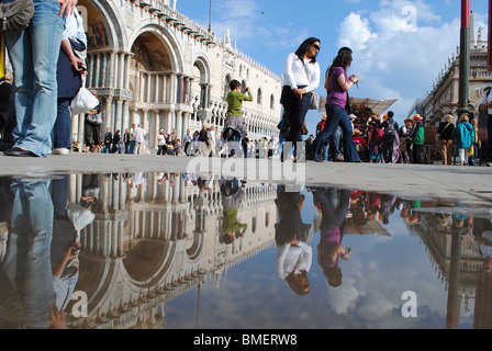 Der Dogenpalast spiegelt sich in einer Pfütze in St. Markus Platz, Venedig, Italien Stockfoto