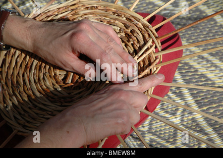 Frau spinnt einen Korb aus Schilf Stockfoto