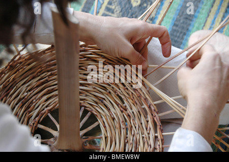 Frau spinnt einen Korb aus Schilf Stockfoto