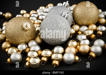 Volle Packung von silbernen und goldenen Weihnachtskugeln auf schwarz Stockfoto