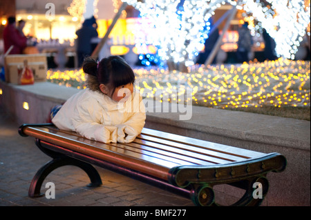 Chinesische Mädchen auf einer Parkbank Solana Lifestyle Shopping Park am Heiligabend, Peking, China Stockfoto