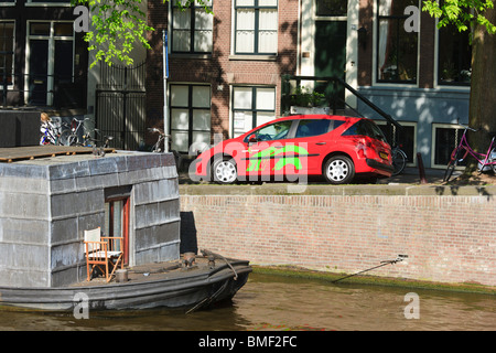 Ein Green Wheels Auto für Car-sharing, dating, kurzfristige Vermietung an einer Gracht in Amsterdam. Peugeot 207. Stockfoto